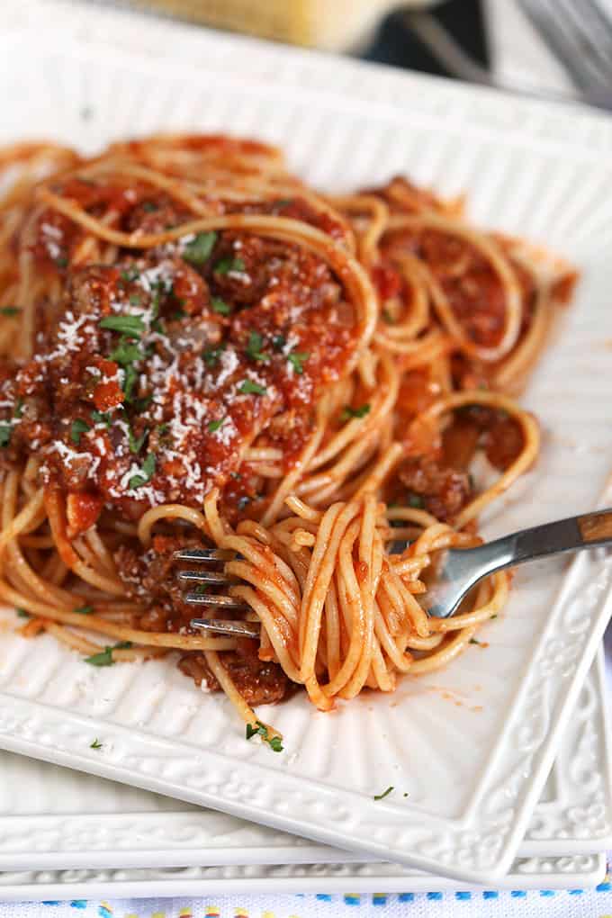 Spaghetti with Easy Italian Meat Sauce recipe on a white square plate with a fork from TheSuburbanSoapbox.com