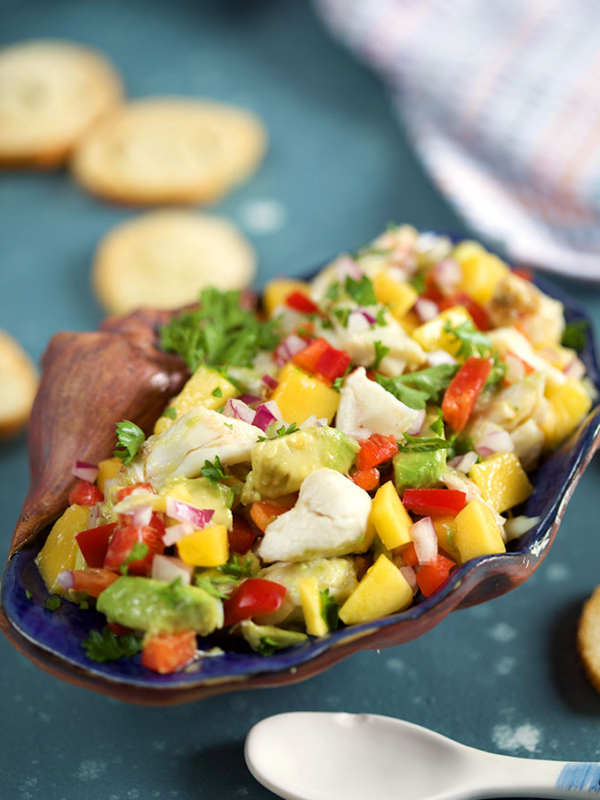 Mango Crab Avocado Salad in a shell on a blue background from TheSuburbanSoapbox.com