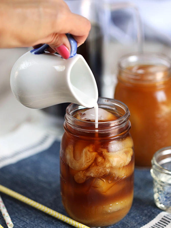 Cold Brew in a mason jar with coconut milk being added from TheSuburbansoapbox.com