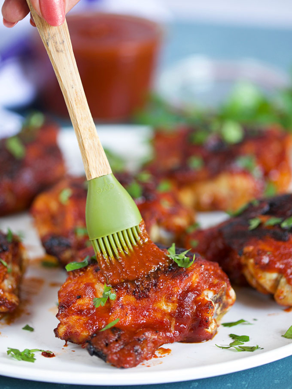Honey Chipotle BBQ Chicken being basted with a green basting brush from TheSuburbanSoapbox.com