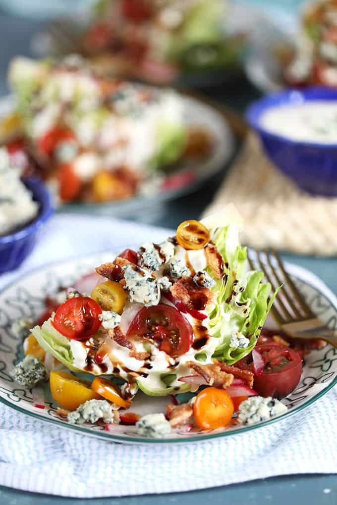 Iceberg Wedge Salad on a white plate with tomatoes, blue cheese and bacon. from TheSuburbansoapbox.com