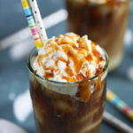 Salted Caramel Vanilla Iced Latte with whipped cream in a glass with paper straws from Thesuburbansoapbox.com