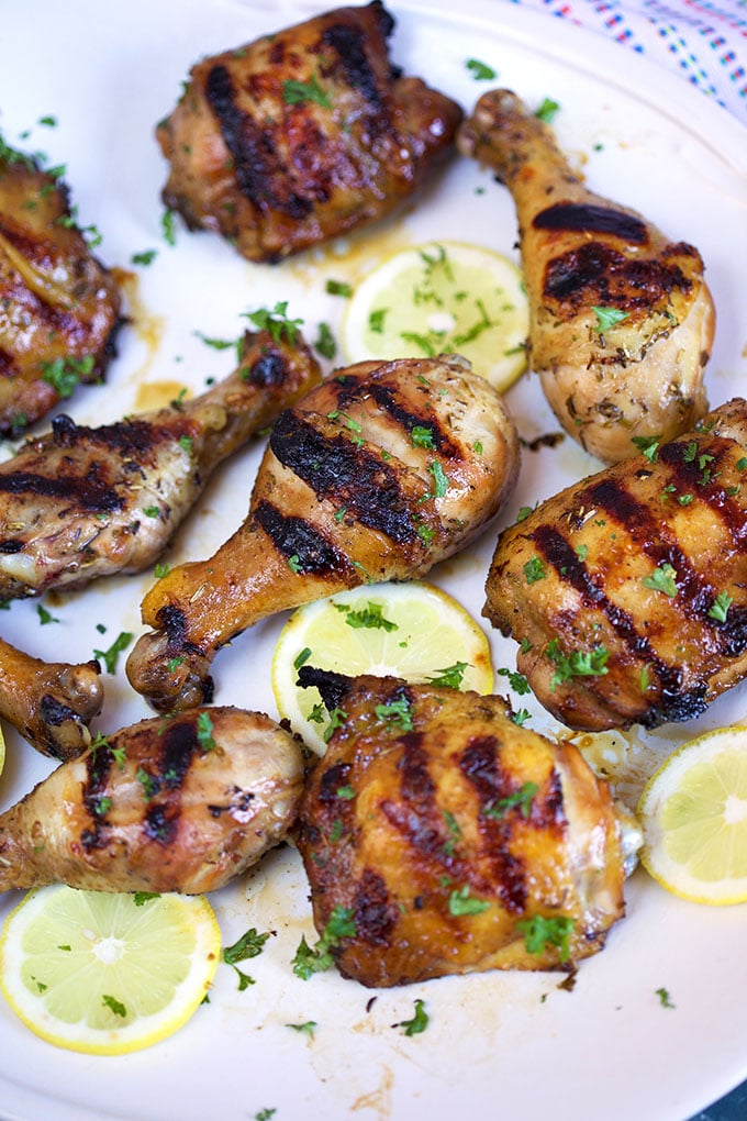 Grilled chicken on a white platter with lemons and parsley from TheSuburbanSoapbox.com