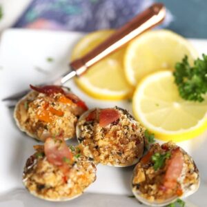 Clams Casino on a white plate with a copper fork from Thesuburbansoapbox.com