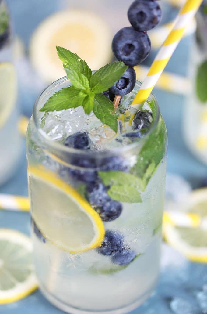 Close up of Lemonade Gin Mojito cocktail on a blue background.