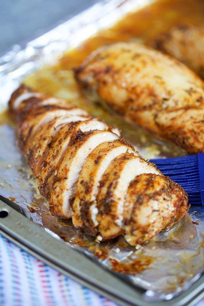 Sliced Baked Chicken Breast on a foil lined baking sheet.