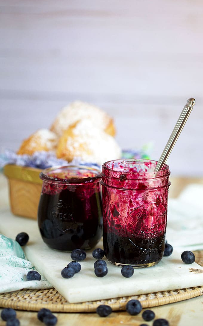 Jars of blueberry jam with a basket of biscuits in the background from TheSuburbanSoapbox.com