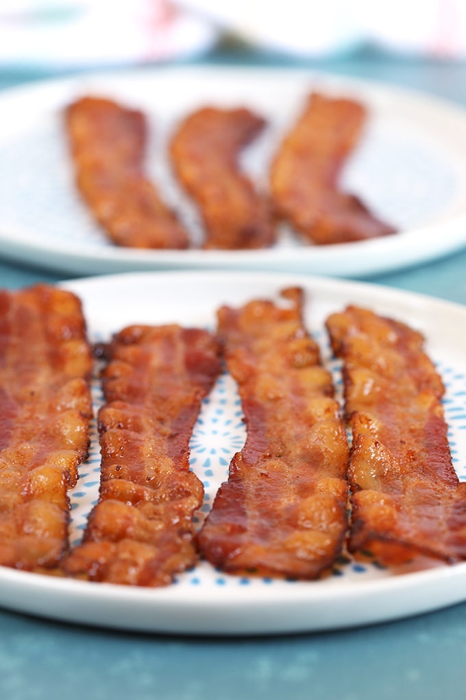 Bacon on a white plate with blue dots on a blue background.