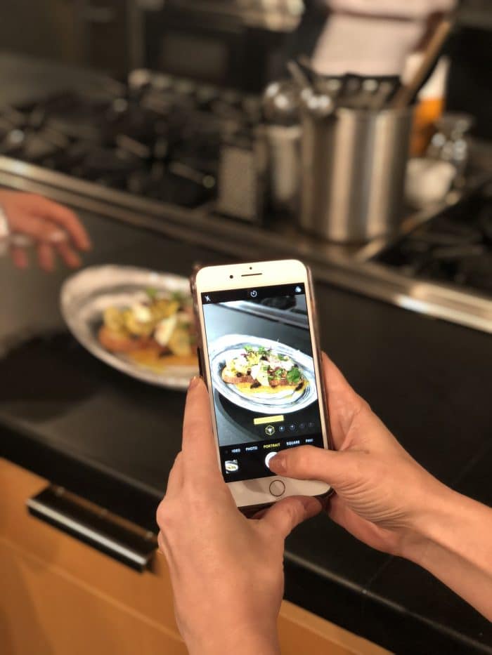 Photo of an iphone taking a picture of a chicken dish.