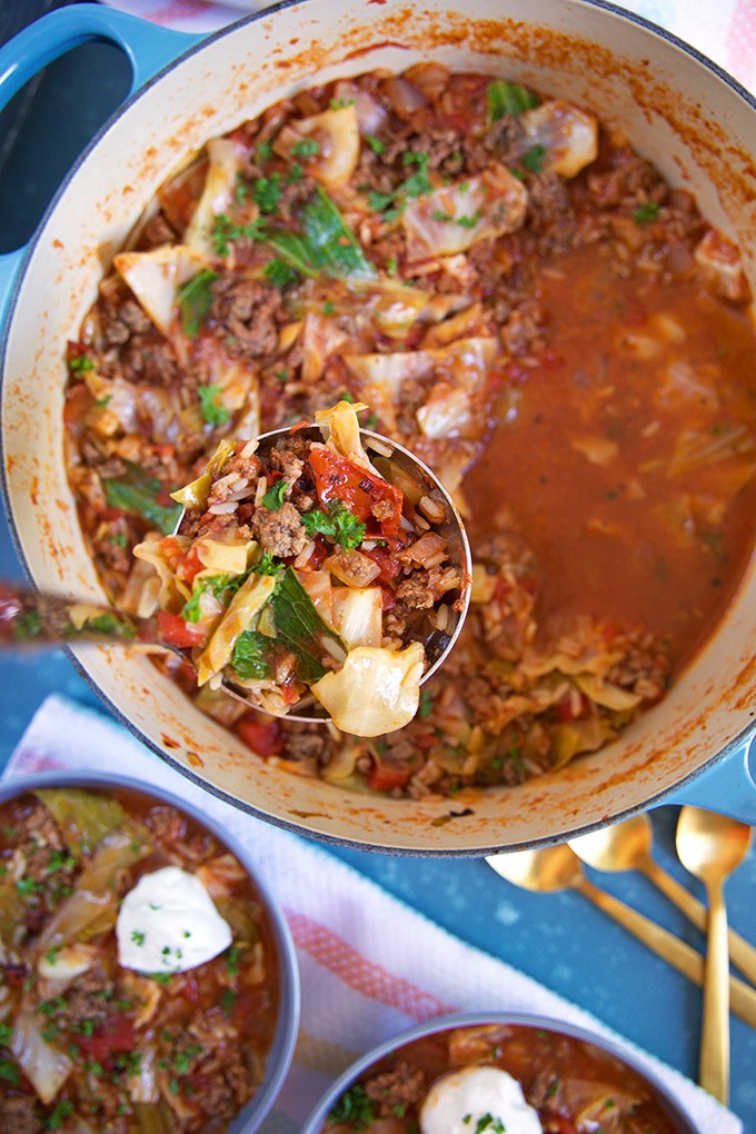 Overhead shot of stuffed Cabbage Soup with a ladle serving soup in a bowl.