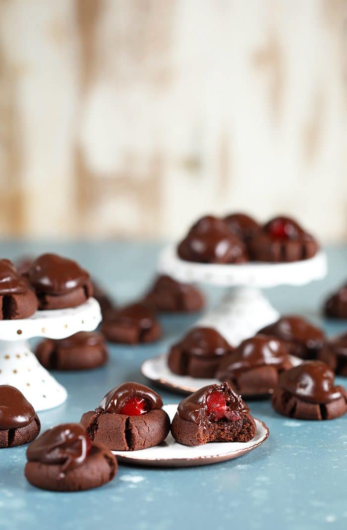 Chocolate Covered Cherry Cookies on white plates on a blue background.