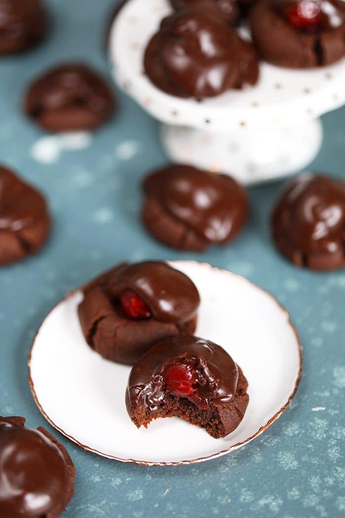 Chocolate Covered Cherry Cookies with a bite taken on a white plate.