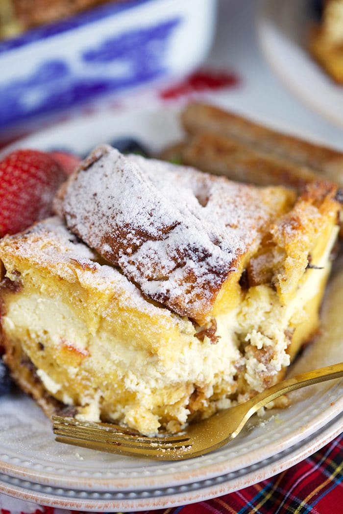Cheesecake stuffed panettone French toast casserole on a white plate.
