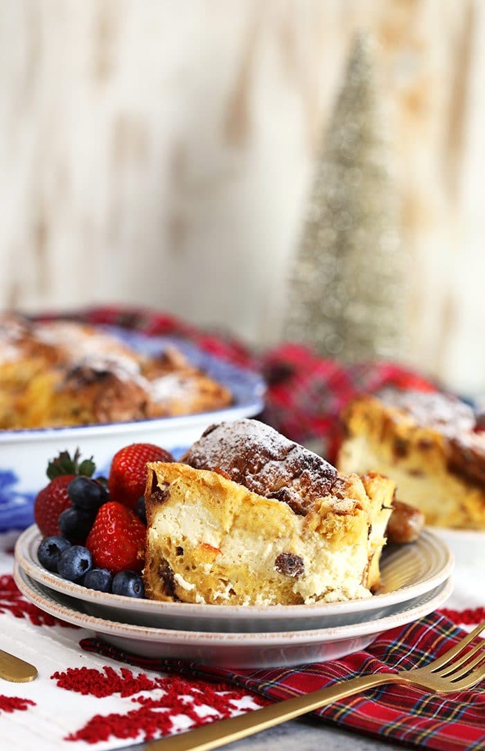 Cheesecake Stuffed Panettone French Toast Casserole on a white plate with plaid napkin.