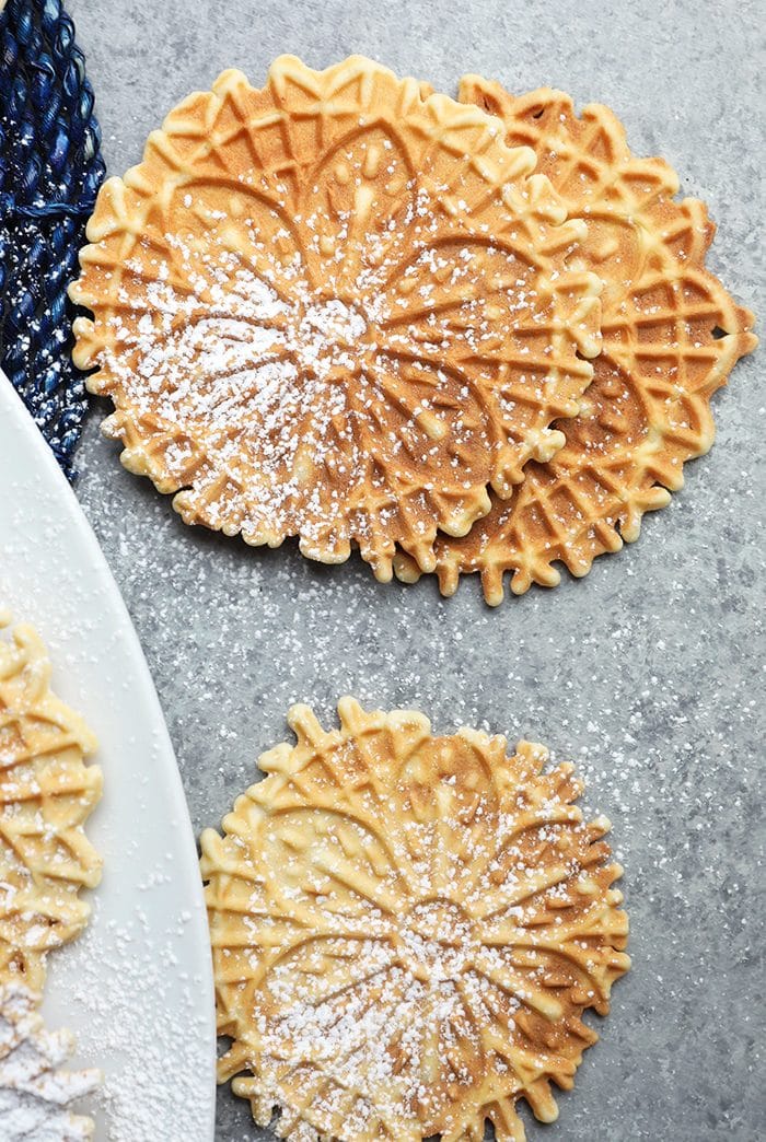 Close up of Pizzelles on a gray background.