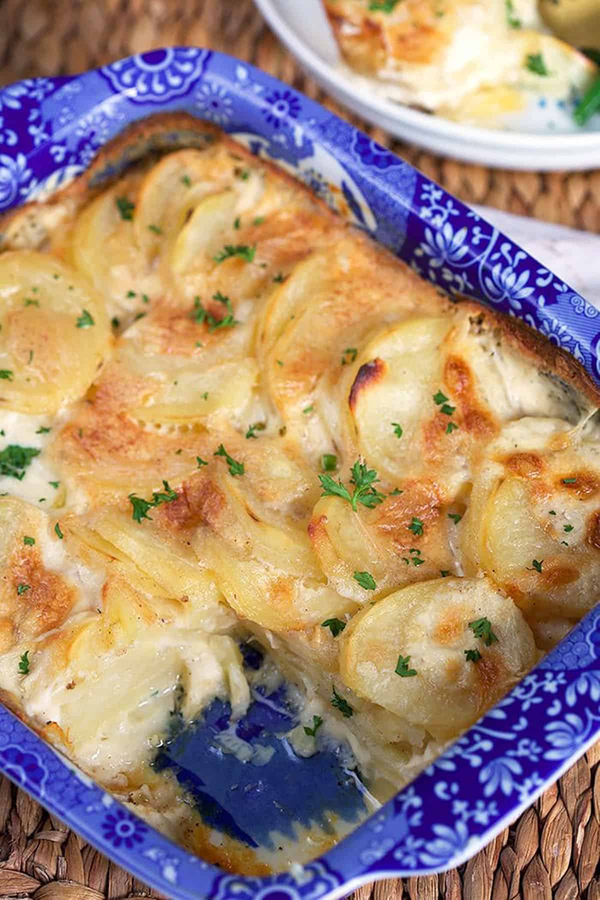 Homemade scalloped potatoes in a blue and white baking dish.