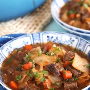 Sweet and Sour Beef Cabbage Soup recipe in a blue and white bowl.