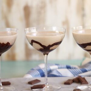 Three chocolate martinis lined in a row on a marble platter.