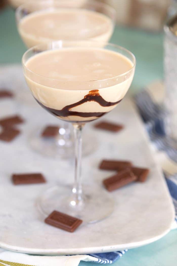 Chocolate martini on a marble platter with chocolate squares around it.