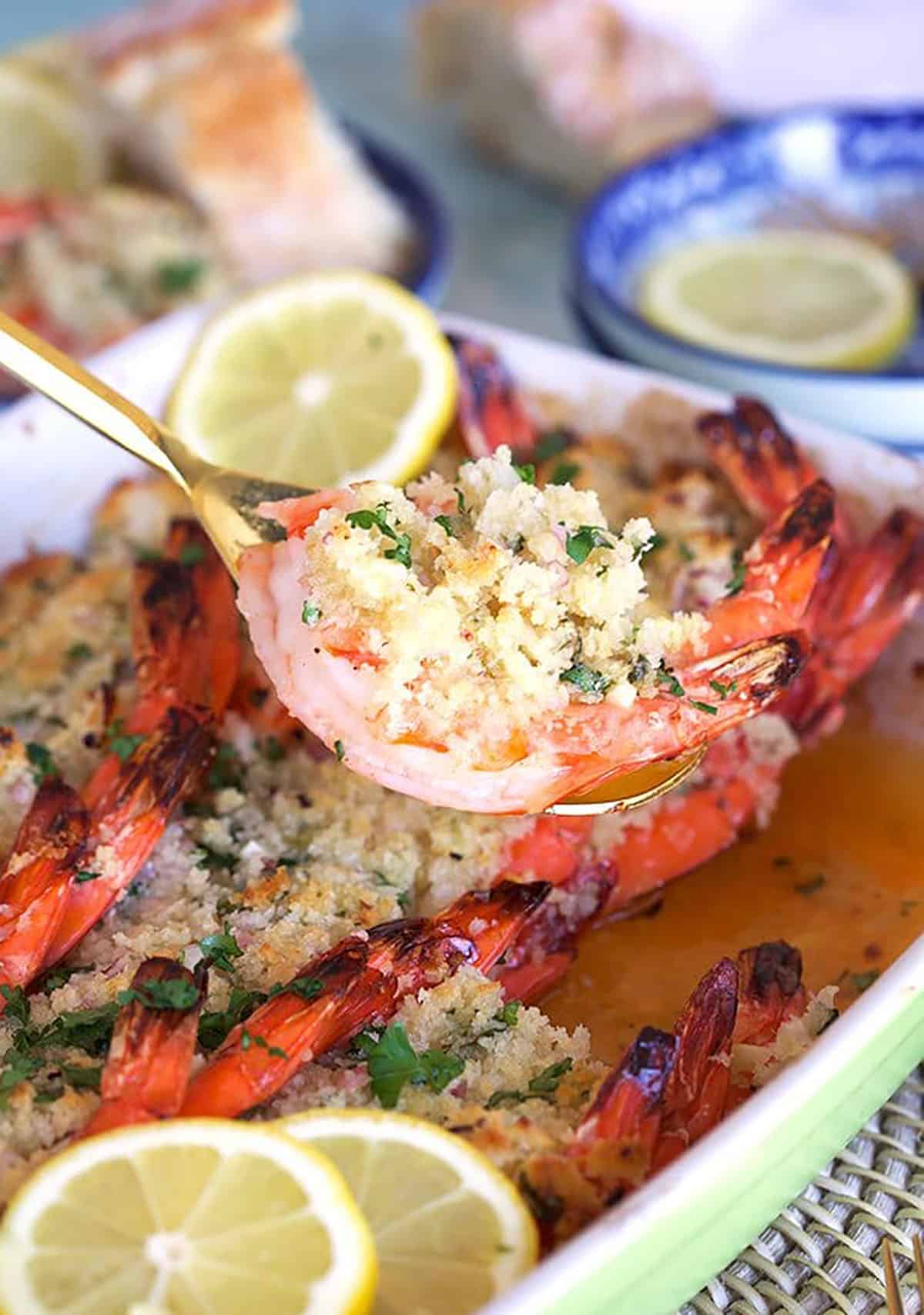 Baked Shrimp Scampi being served with a gold serving spoon.
