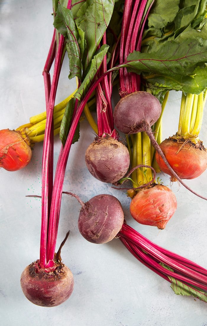 Pile of beets on a blue background.