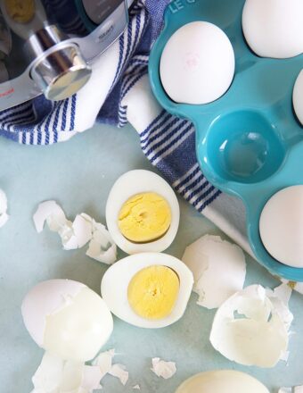 Overhead shot of hard boiled eggs with an Instant Pot and a blue egg crate.