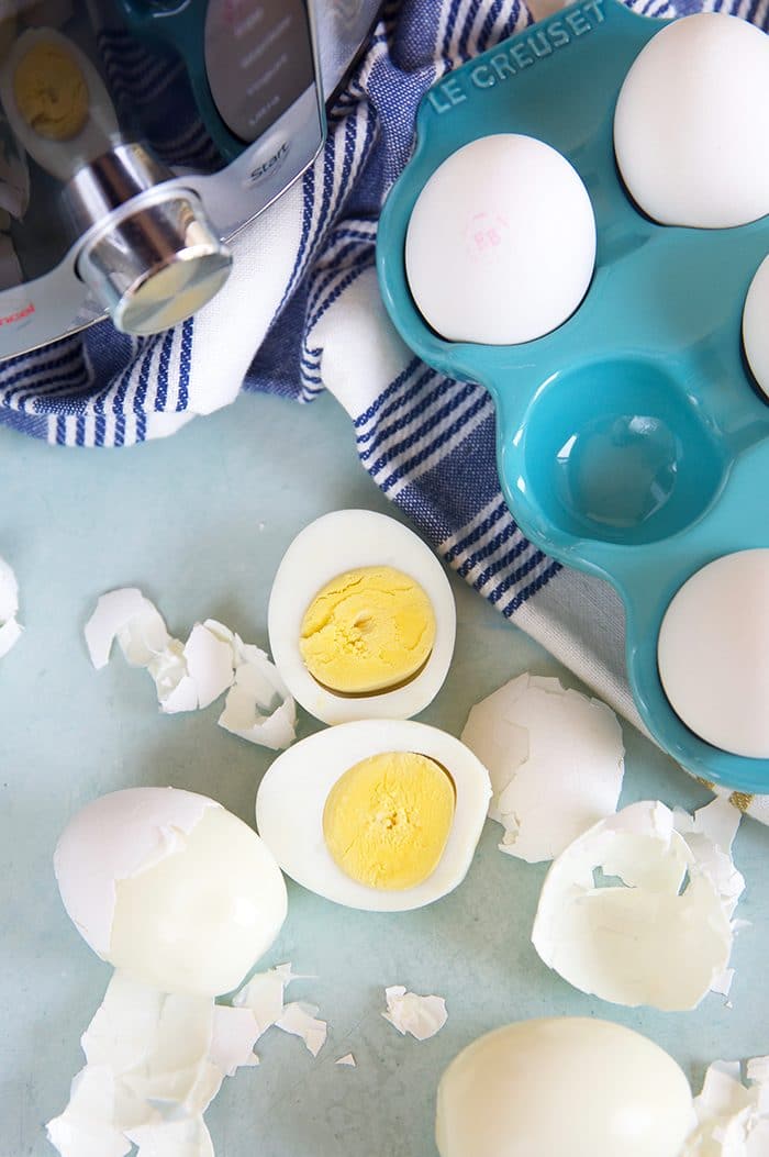 Overhead shot of hard boiled eggs with an Instant Pot and a blue egg crate.