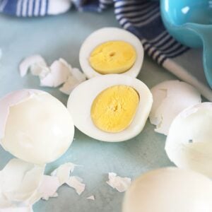 Hard boiled eggs cut in half with shells around.
