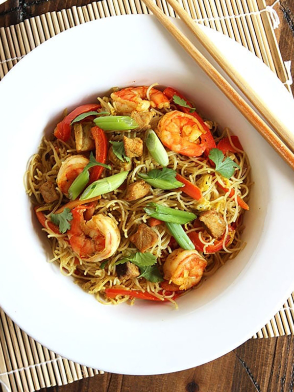 Spicy Singapore Chow Mei Fun in a white bowl with chopsticks resting on the side.