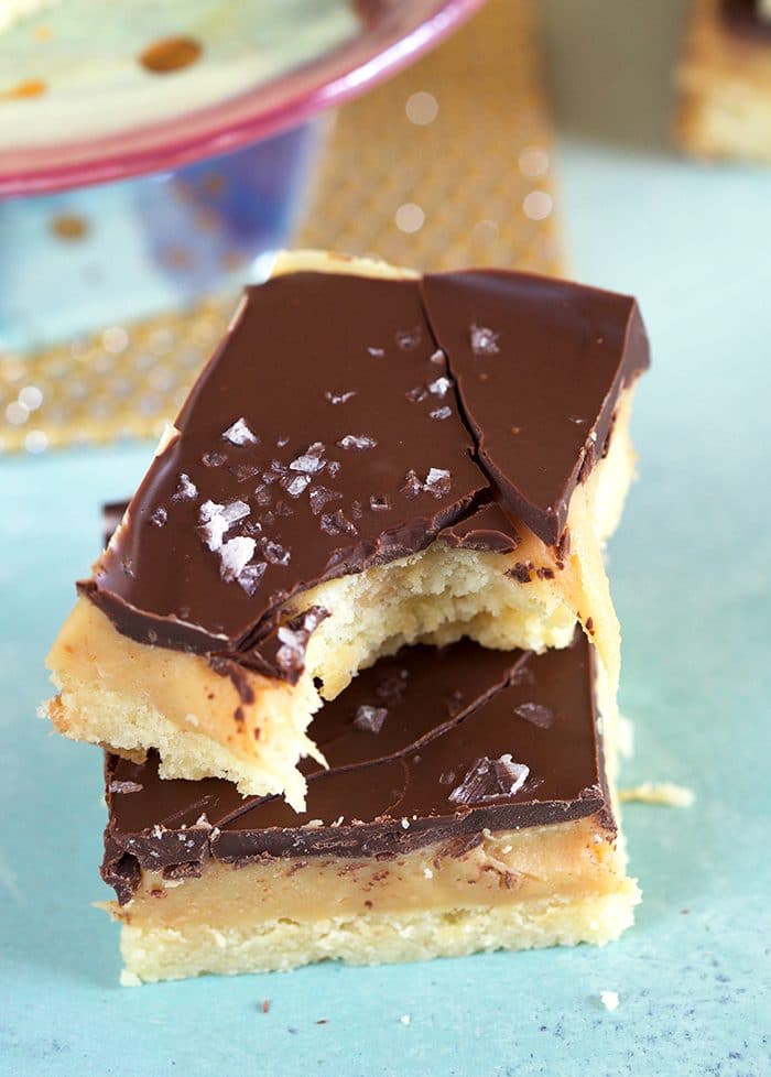 Close Up of Millionaire Shortbread with a bite taken on a blue background.
