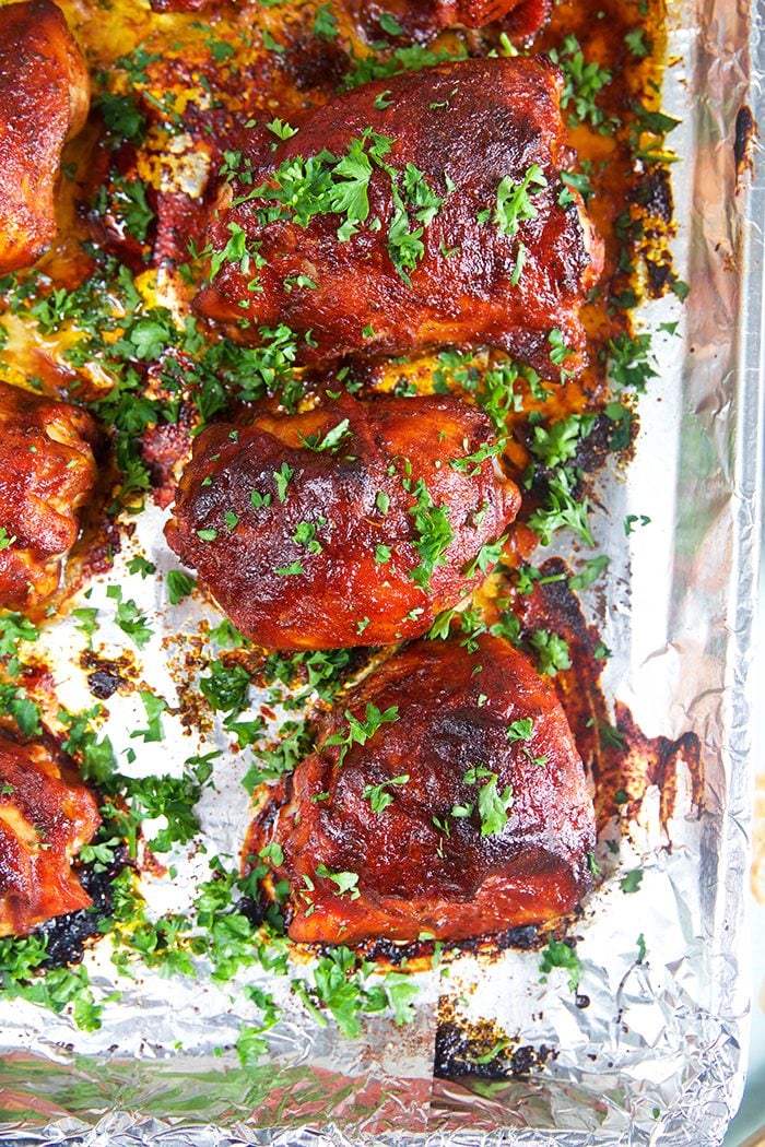 Barbecue Chicken thighs on a baking sheet.