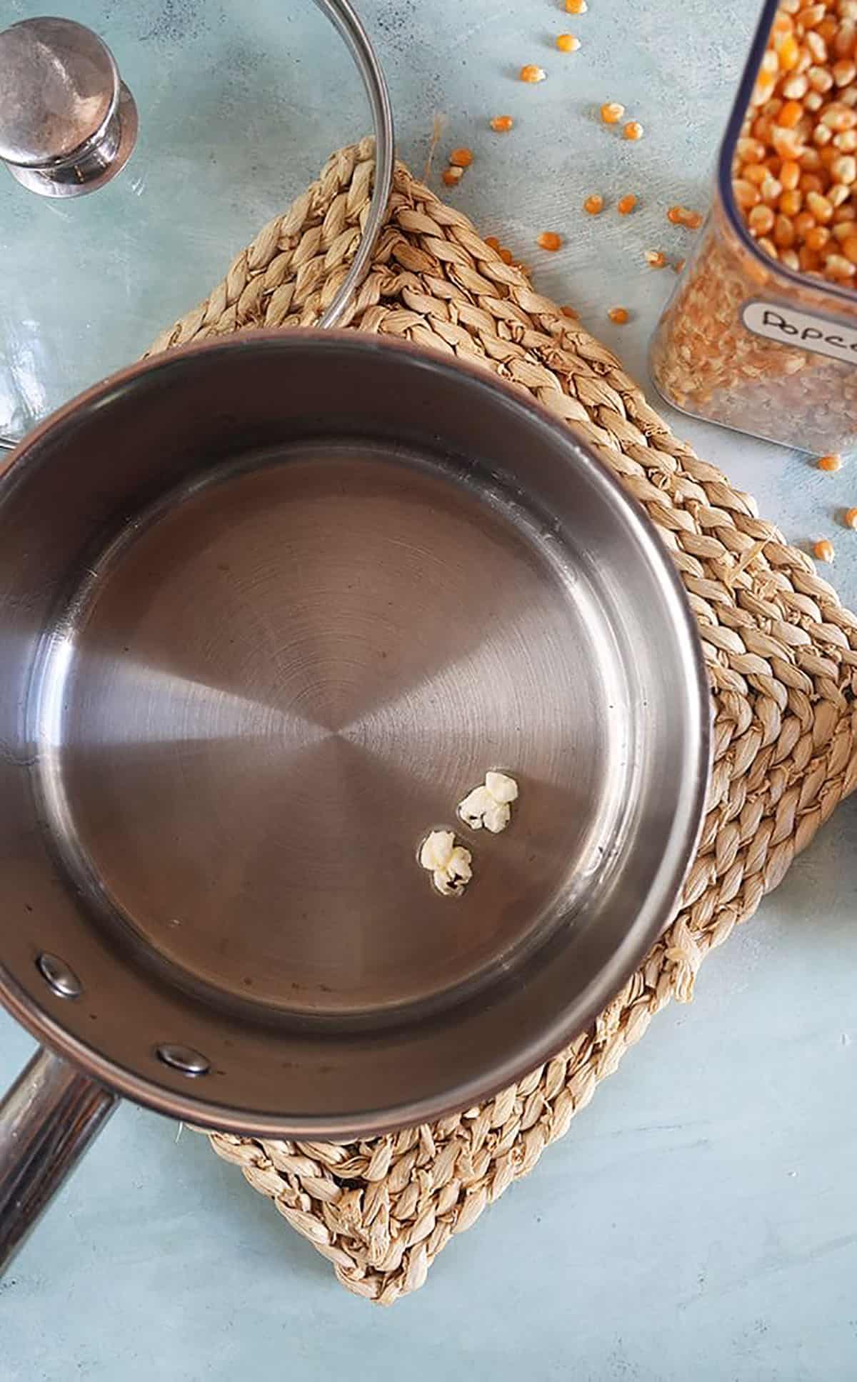 Two popcorn pieces in a pot of oil.