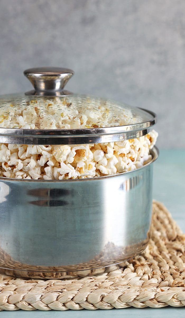 Closeup of popcorn in a pot with a glass lid.
