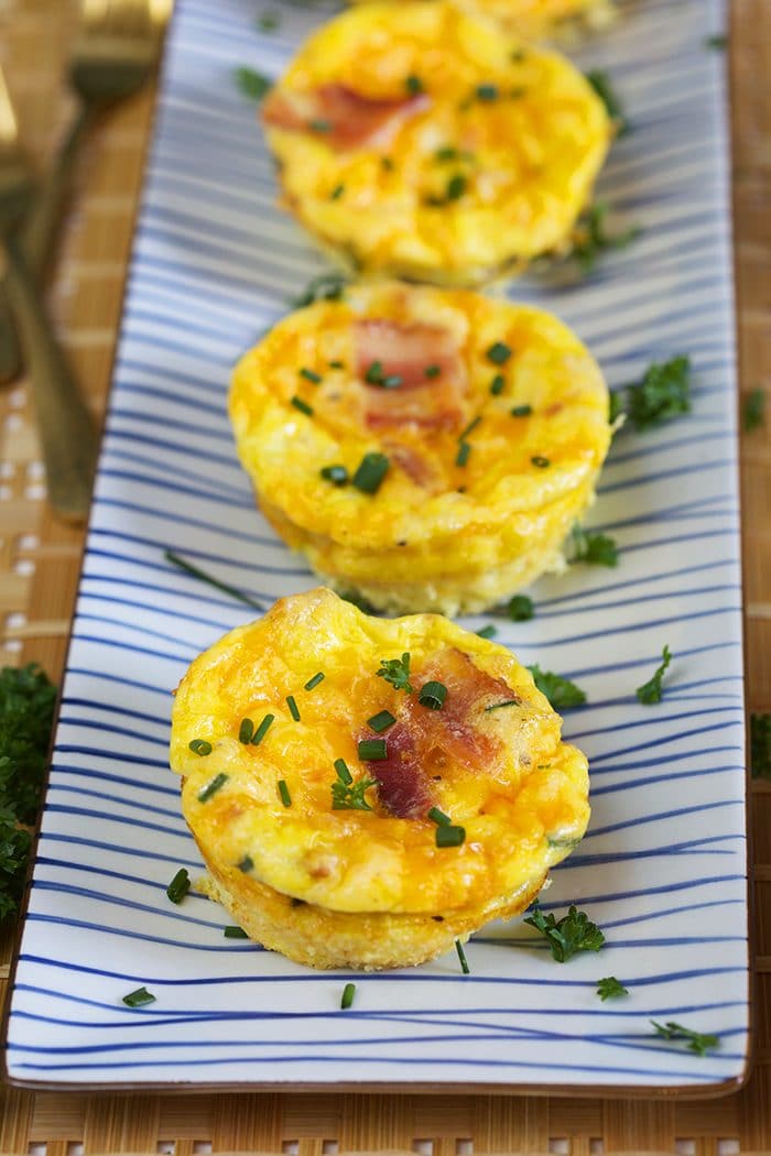 Bacon Cheddar Egg Muffin Cups on a blue and white striped platter.
