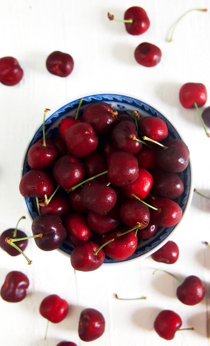 Bowl of cherries on a white background.