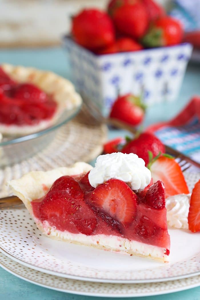 Slice of strawberry pie with cream cheese on a white plate.