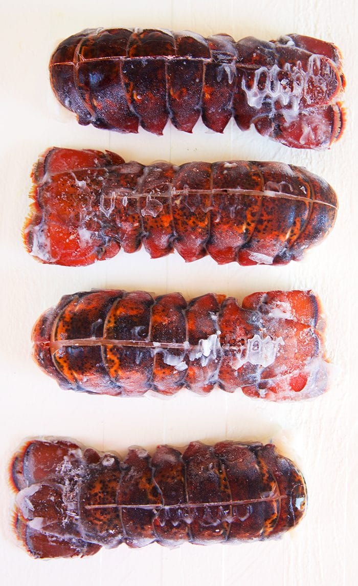 Frozen lobster tails on a white background.