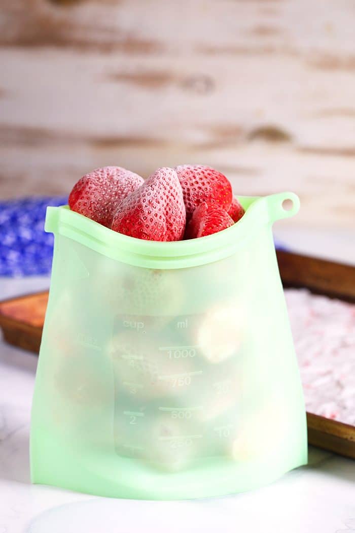 Frozen strawberries in a silicone freezer bag.