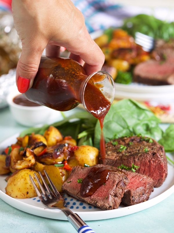 Sauce being drizzled on a steak.