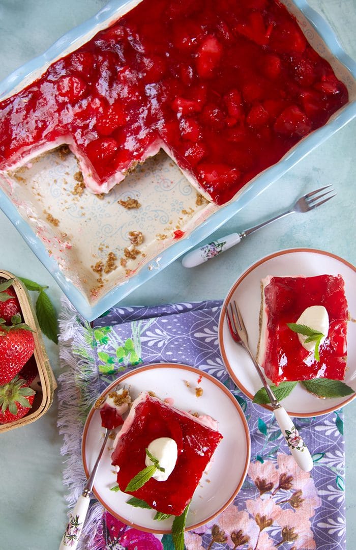 overhead shot of two slices of strawberry pretzel salad and a baking dish.