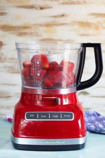 Strawberries in the bowl of a blender.