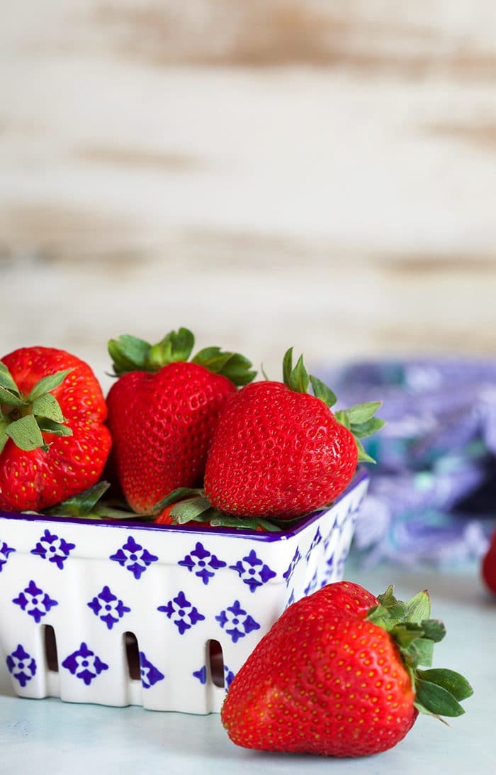 Strawberries in a ceramic blue and white berry container.
