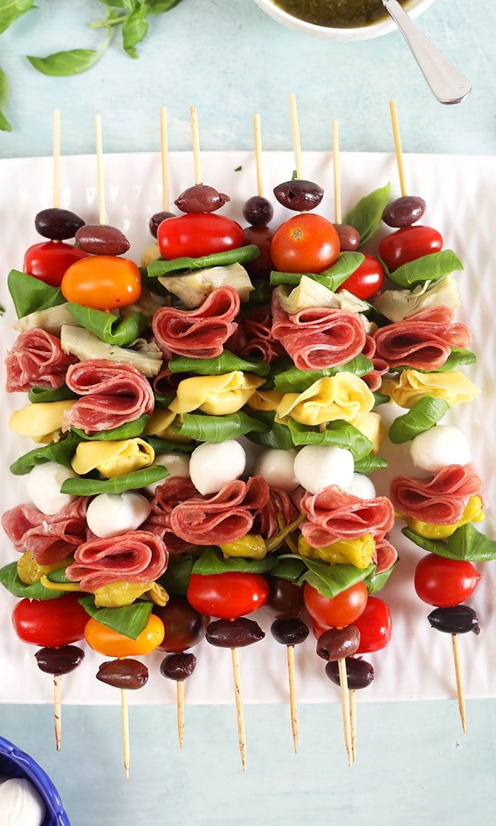 Antipasto skewers on a white square platter.