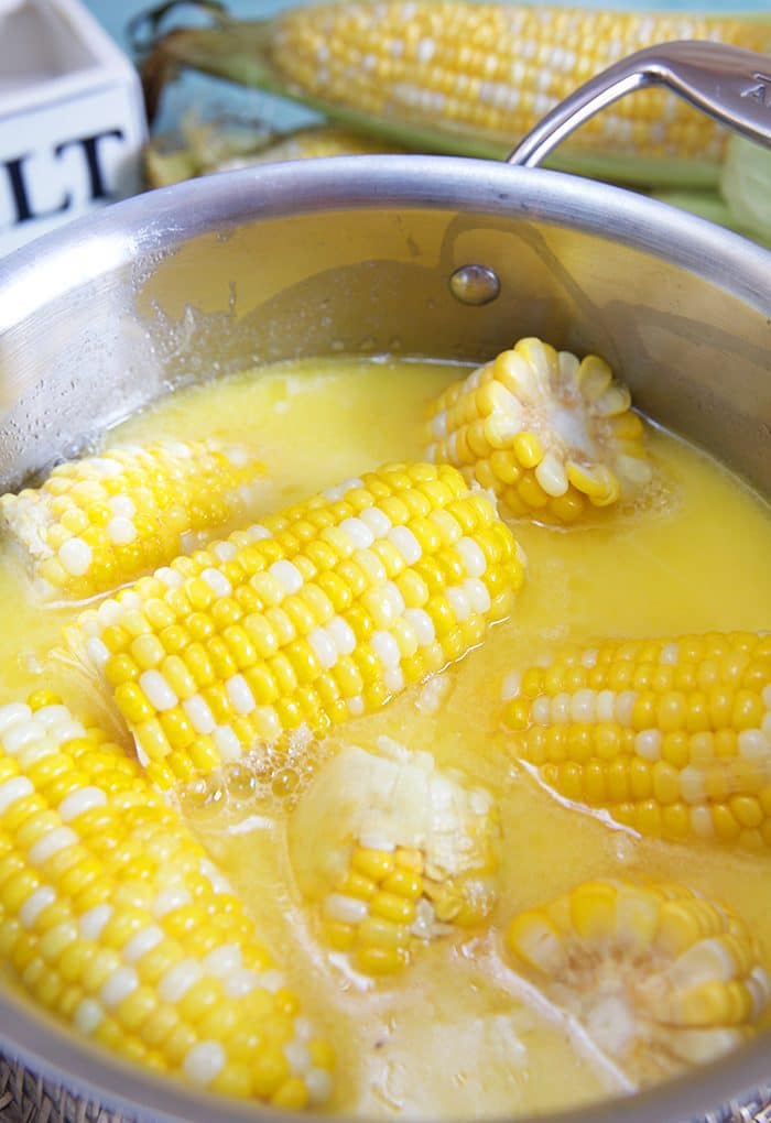 Corn on the cob in a stainless steel pot.