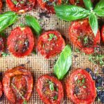 Close up of oven roasted tomatoes with basil and herbs.