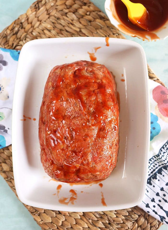 MEatloaf in a baking dish with glaze on it before baking.