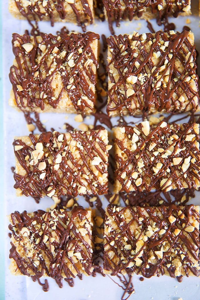 Overhead shot of peanut butter rice krispie treats with chocolate on a piece of parchment.