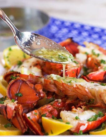 Grilled Lobster Tails with butter sauce being drizzled overtop.