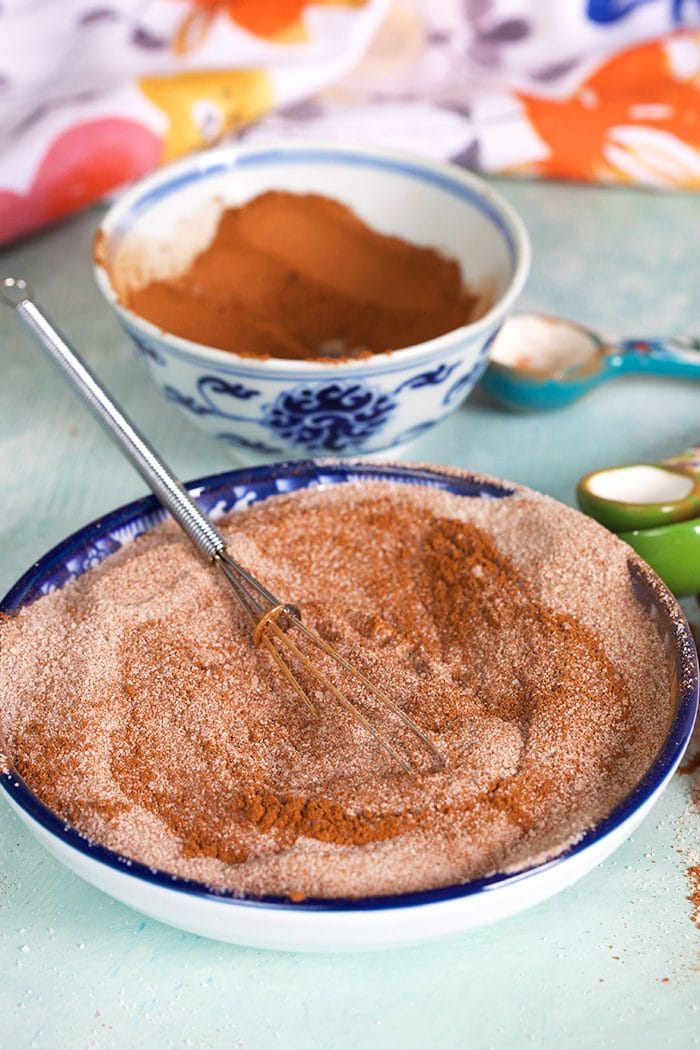 bowl of cinnamon sugar with a whisk.