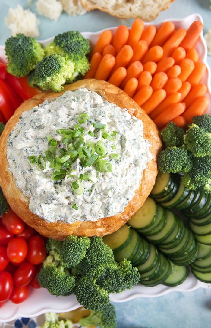 Overhead shot of Knorr Spinach Dip in a bread bowl with vegetables on a platter.